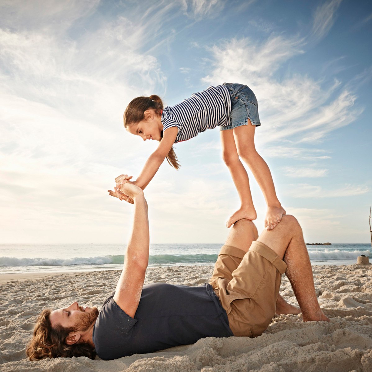 Vater und Tochter spielen am Strand