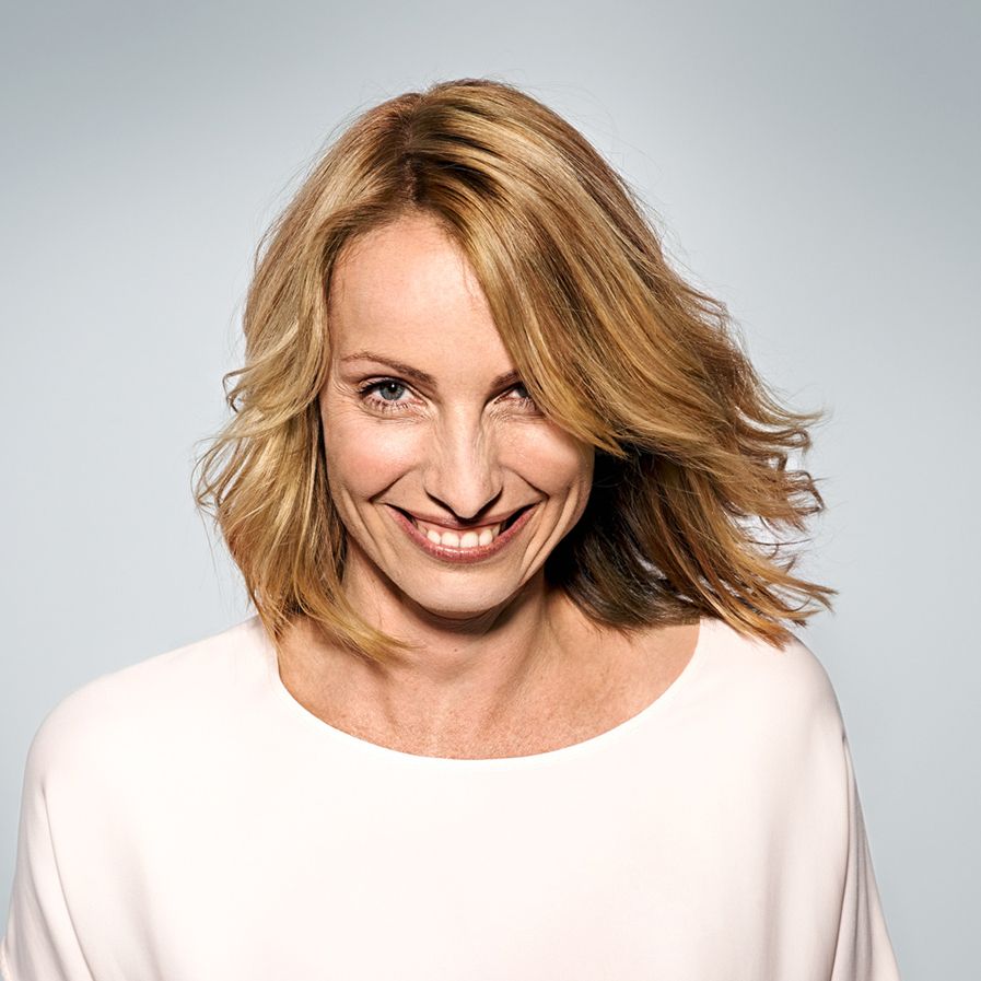 Lachende Frau im Studio vor hellem Hintergrund