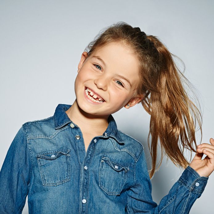 Lachendes Mädchen im Jeanshemd im Studio