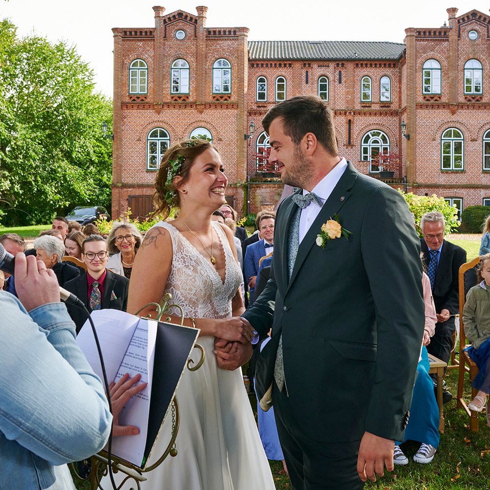 Brautpaar bei der freien Trauung vor dem Gutshaus