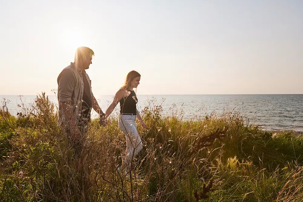 Paar geht Hand in Hand am Meer entlang
