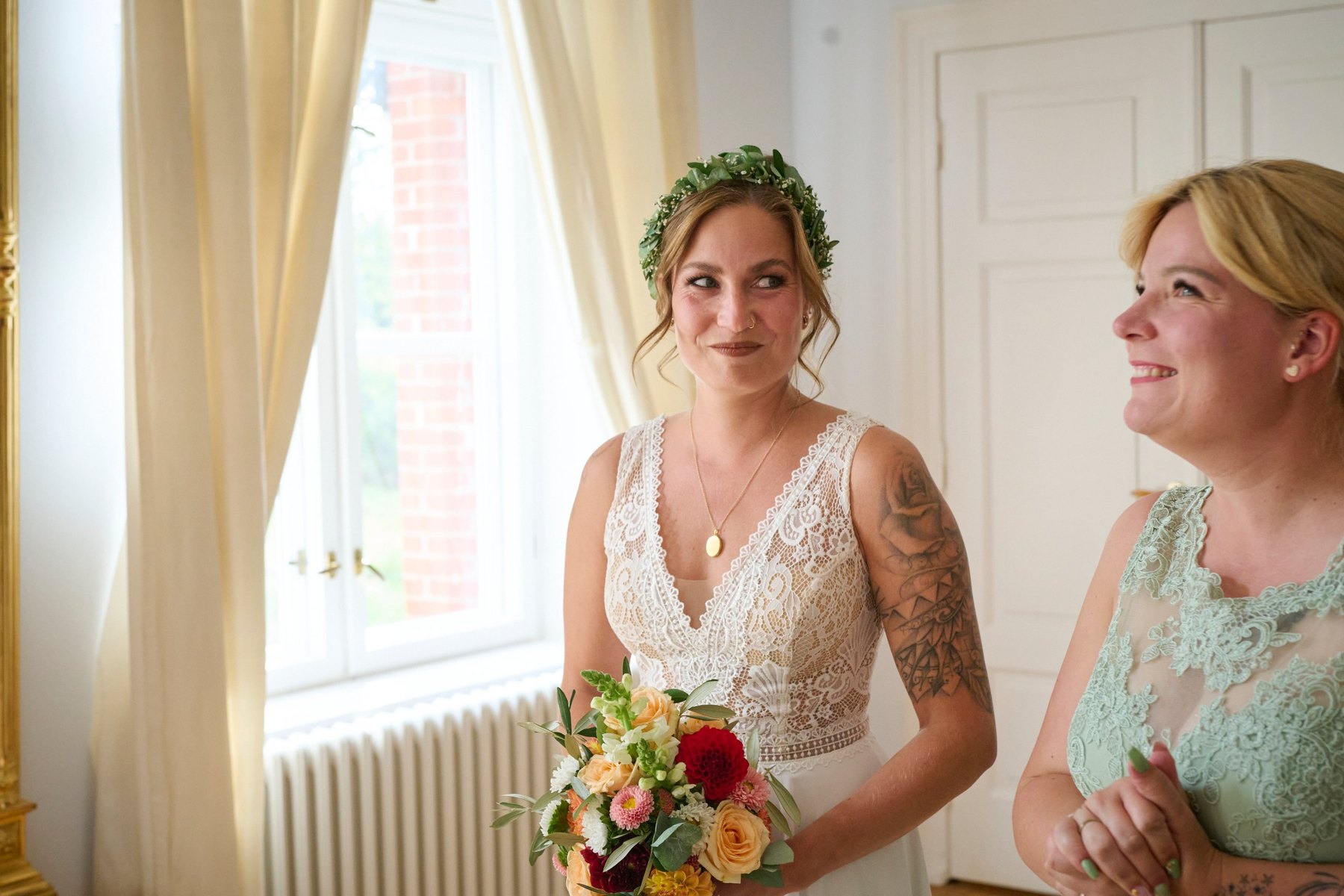 Braut mit Blumenkranz und ihre Trauzeugin vor der Trauung