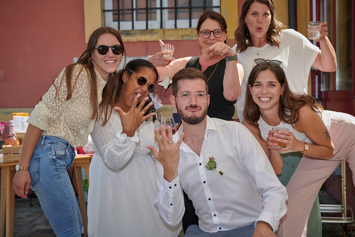 Brautpaar albert mit Freundinnen herum und zeigt die Ringe