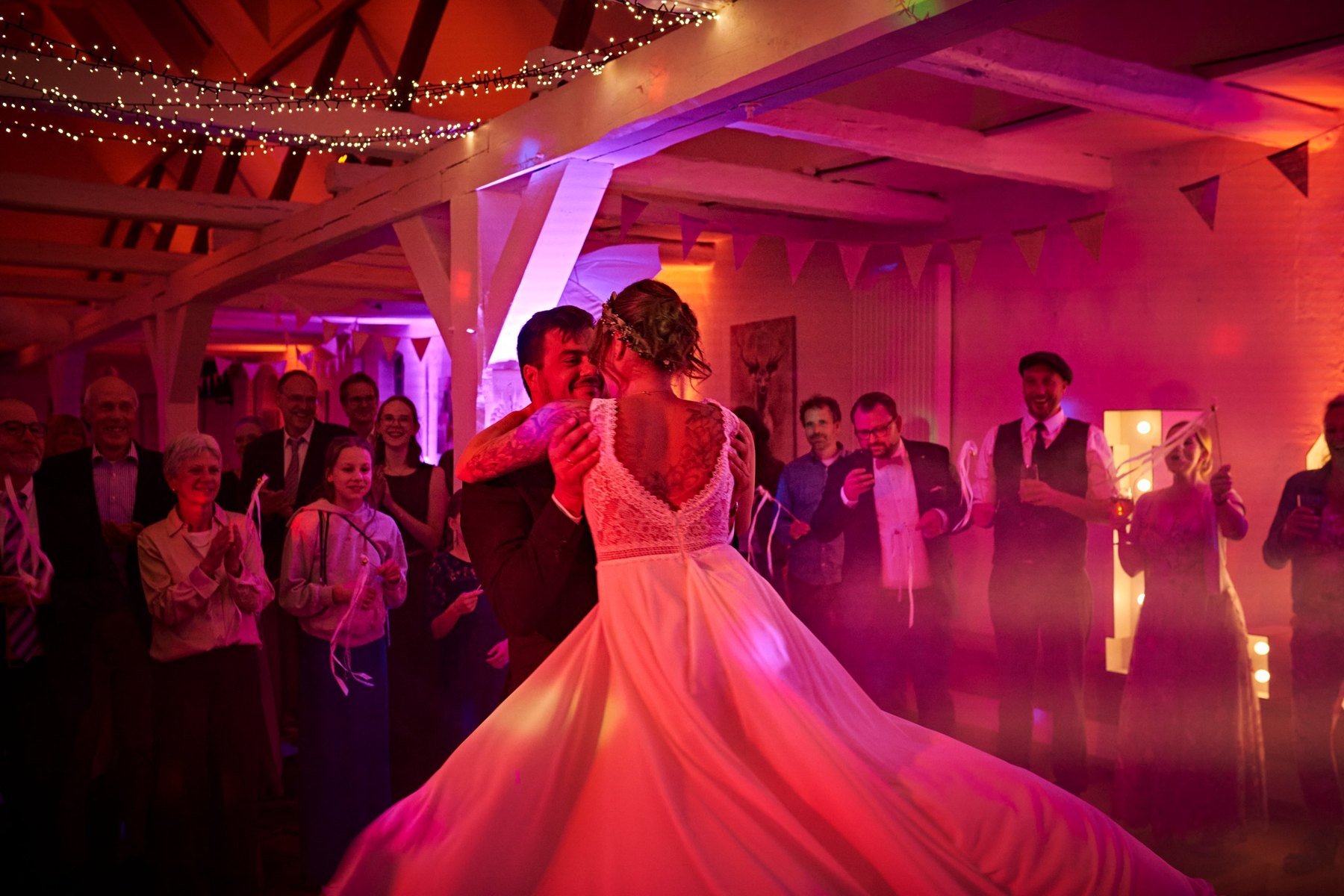 Hochzeitstanz im bunten Licht, die Gäste stehen im Kreis